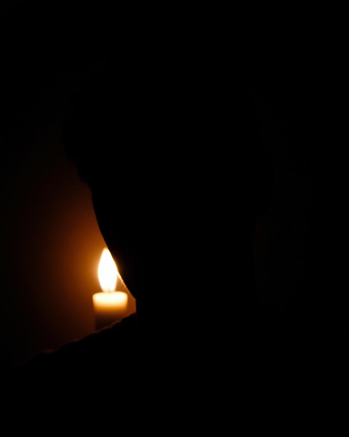 A candlelit portrait in shadow